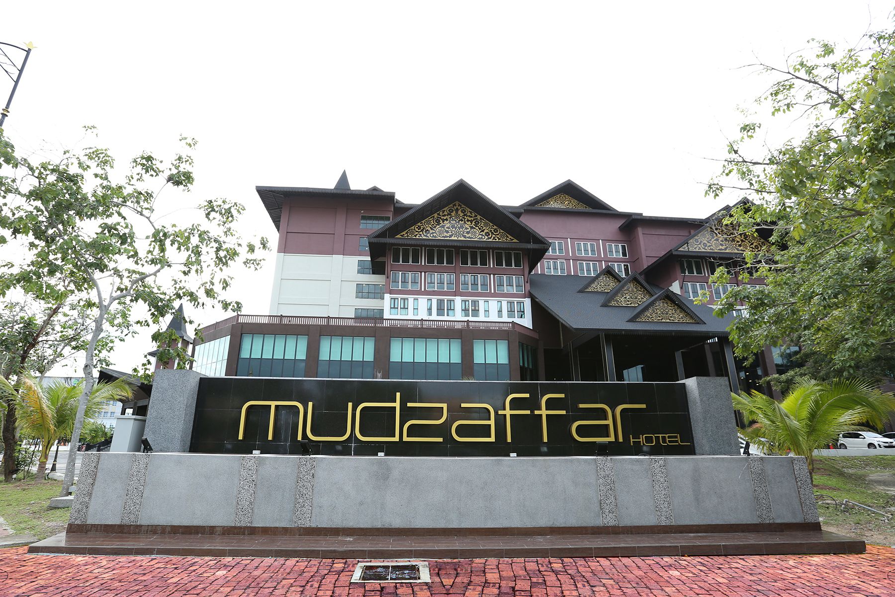 A hotel with a modern architectural design, featuring a prominent entrance with a large sign.