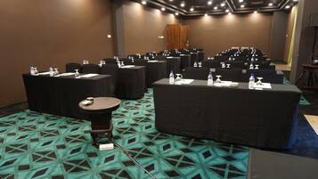 A conference room with tables and chairs, water bottles, and name tags on each table.