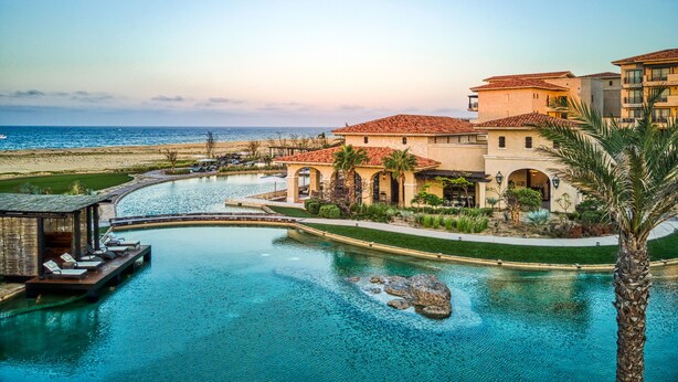 Un resort con piscina, playa y vista al océano.