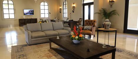 A spacious living room with a sofa, coffee table, and decorative vase.