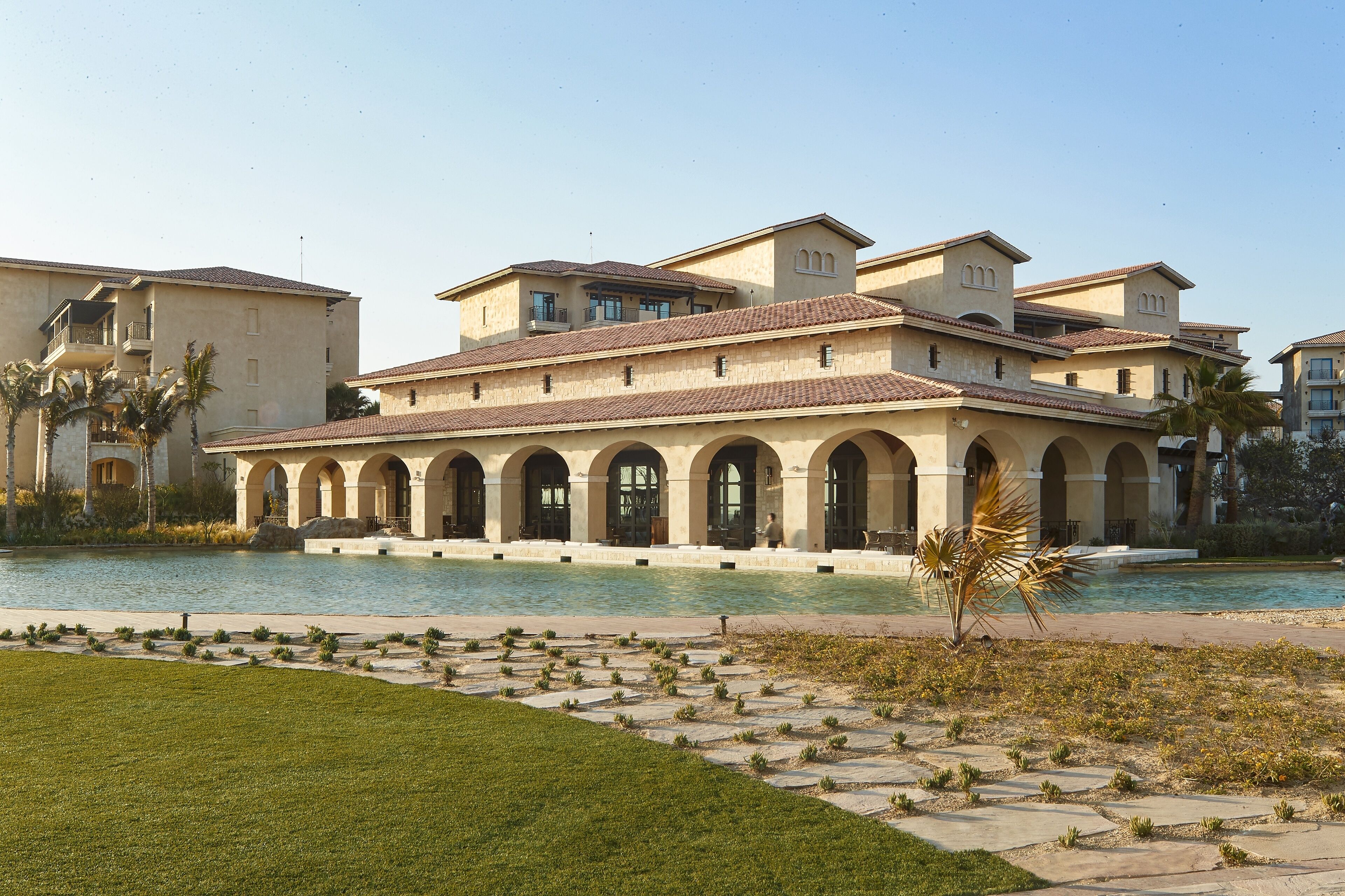 A Mediterranean-style building with multiple arches and a pool.