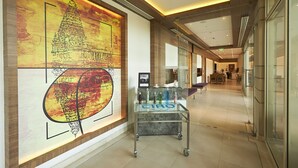 A corridor with a glass display table, a mural of a temple, and a modern interior design. - Mercure Chennai Sriperumbudur Hotel (Sriperumbudur)