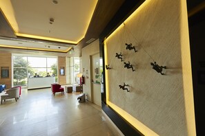 A spacious lobby with a reception desk, seating area, and a wall-mounted sculpture. - Mercure Chennai Sriperumbudur Hotel (Sriperumbudur)