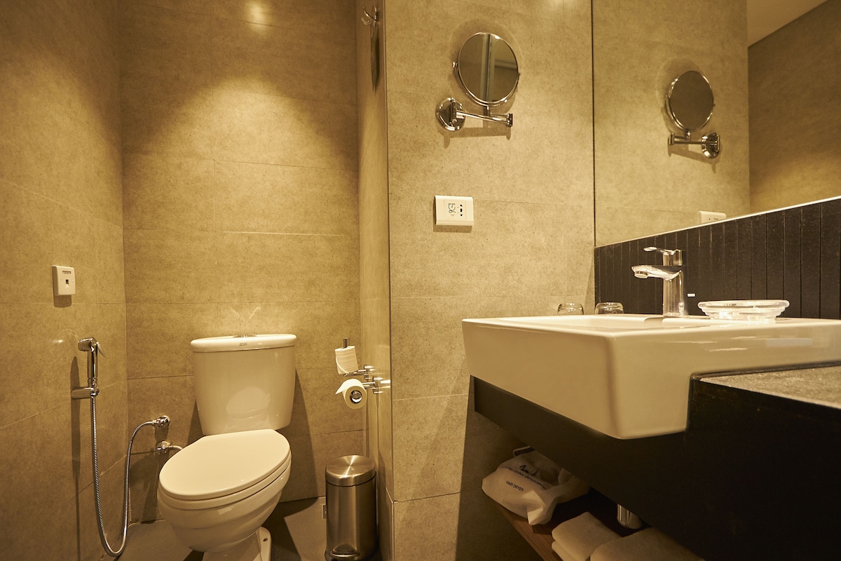 A modern bathroom with a toilet, bidet, and sink.