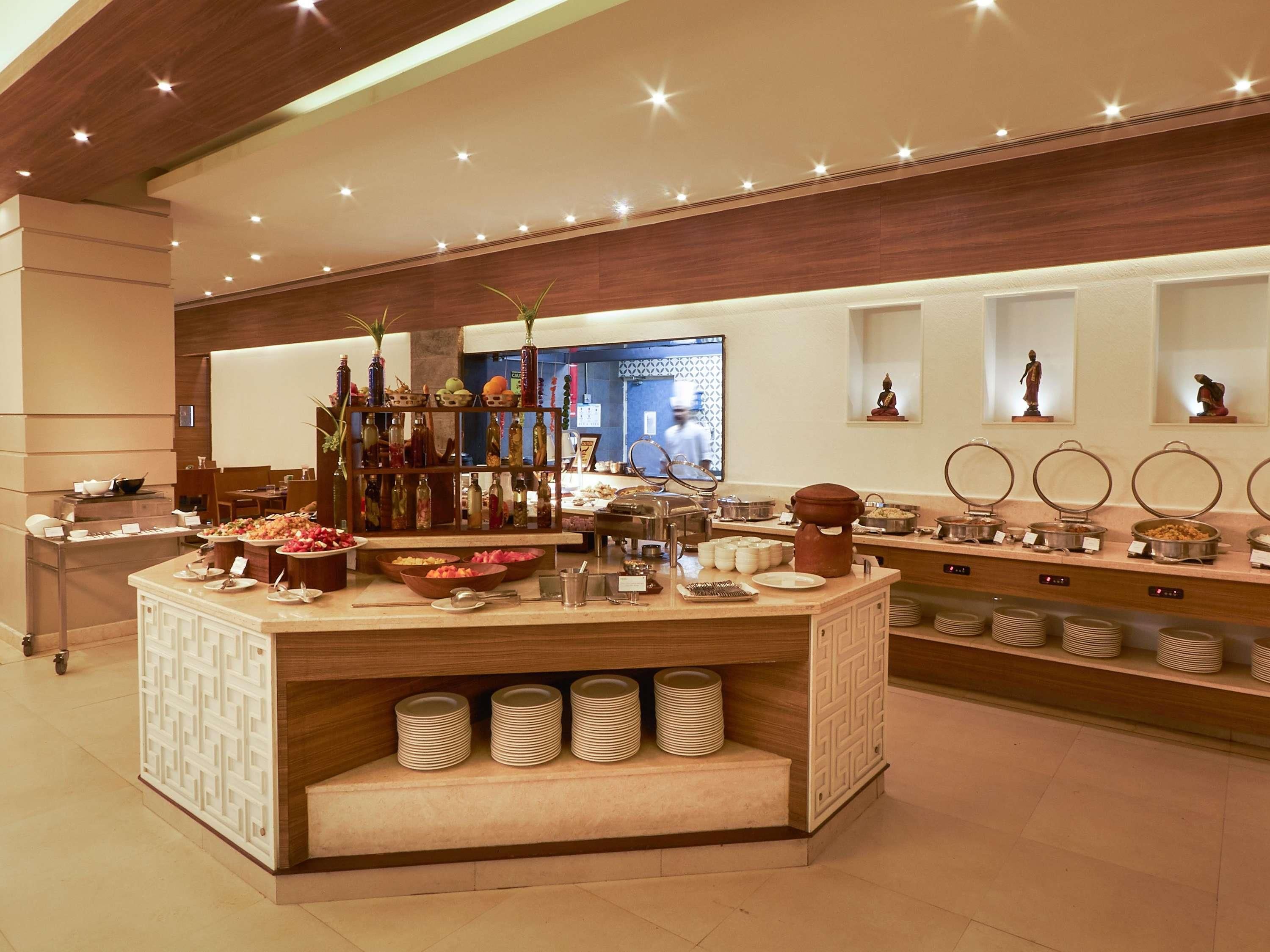 Una mesa de buffet con diversos alimentos, una estación de café y una exhibición de botellas decorativas.