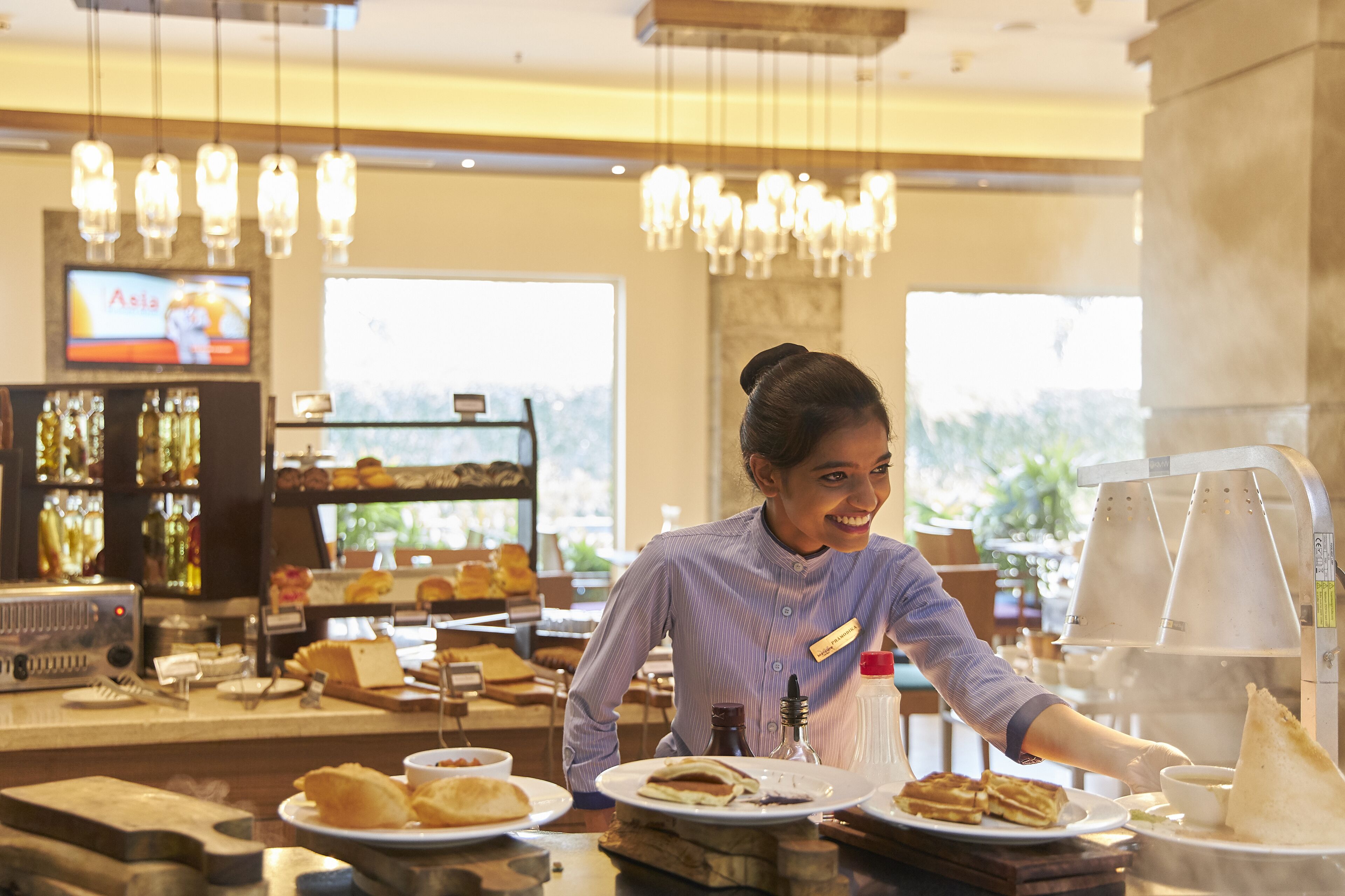 A restaurant interior with a bar area, a coffee machine, and a display of pastries.