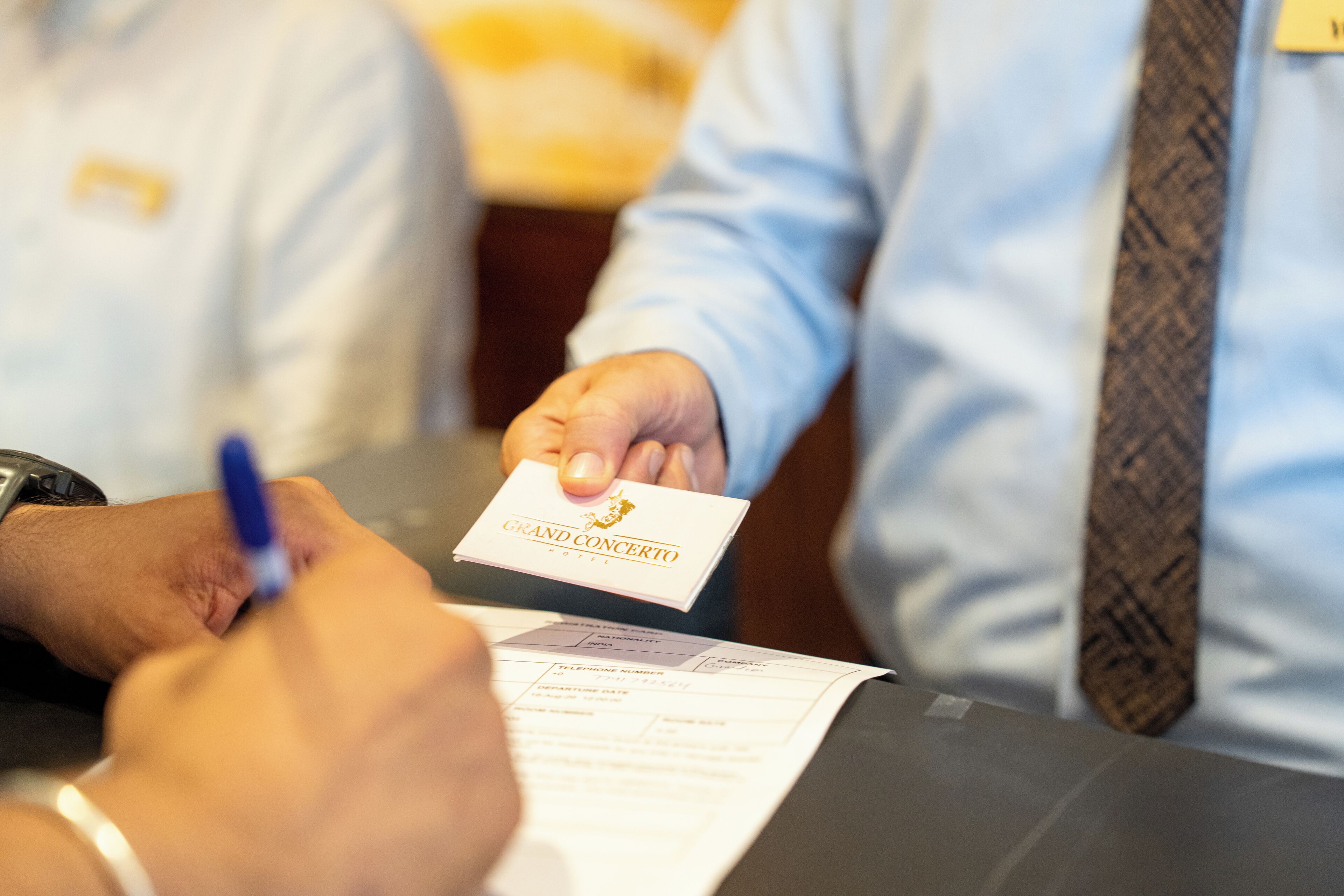 Una persona firmando un documento en la recepción de un hotel.