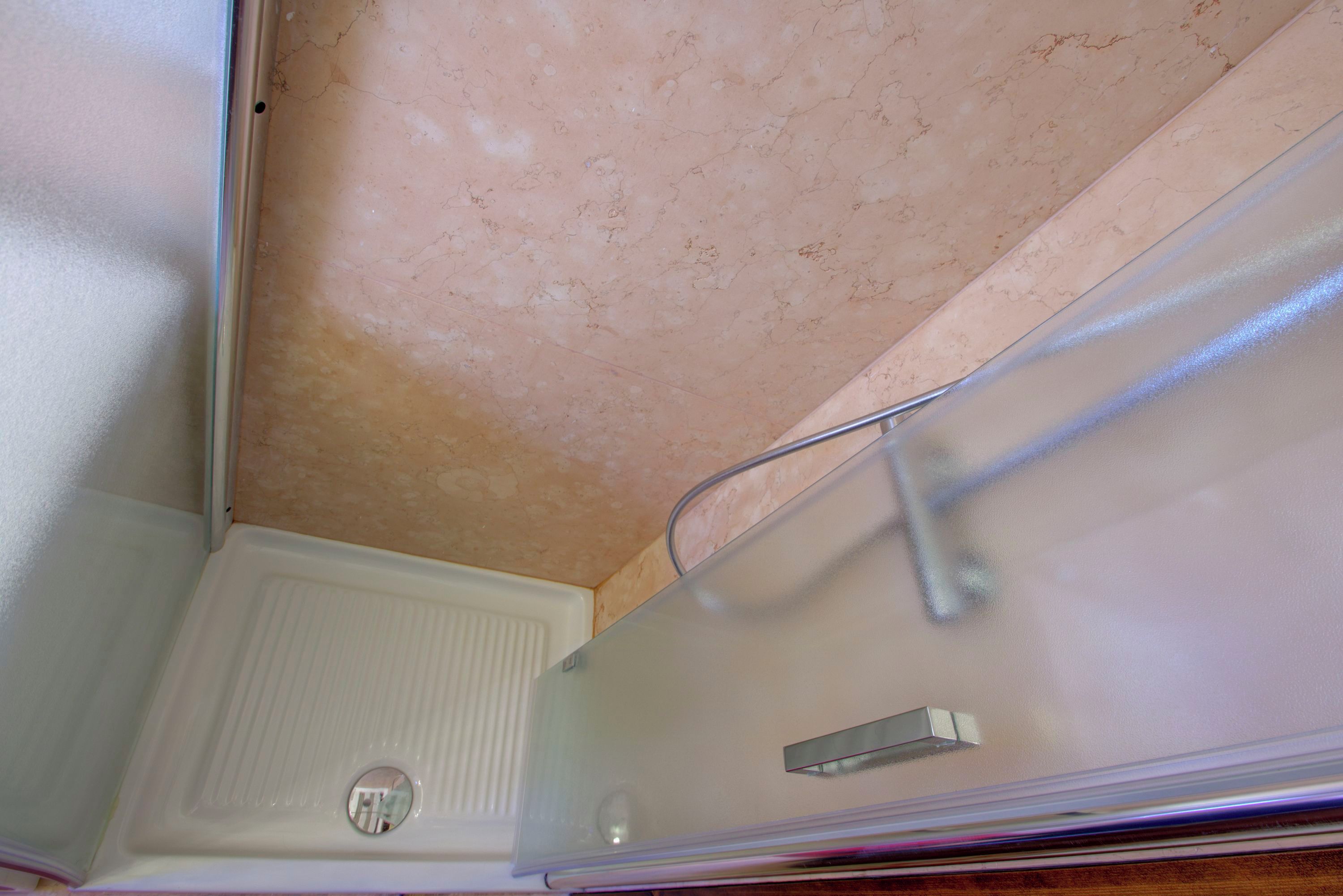 A bathroom with a shower, a toilet, and a sink.