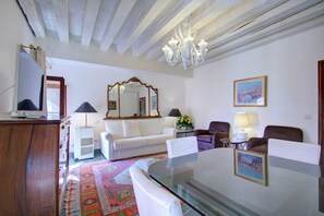 A living room with a glass-top table, white sofa, and a patterned rug. - ZANIPOLO Marco-canal (Venice)