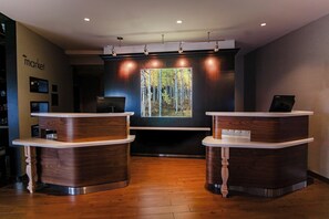 Un área de recepción con dos mostradores de madera, un ventanal con vistas a un bosque y un cartel en la pared que dice "market".