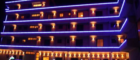 A multi-story hotel with a modern design, featuring a prominent horizontal light strip along the facade.