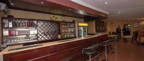 A bar area with a counter, stools, and a wine rack.