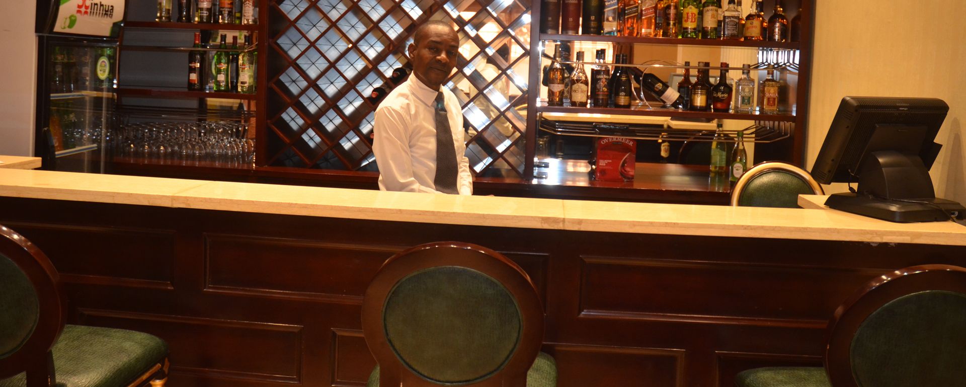 A bar area with a counter, shelves of liquor bottles, and a glass display case.