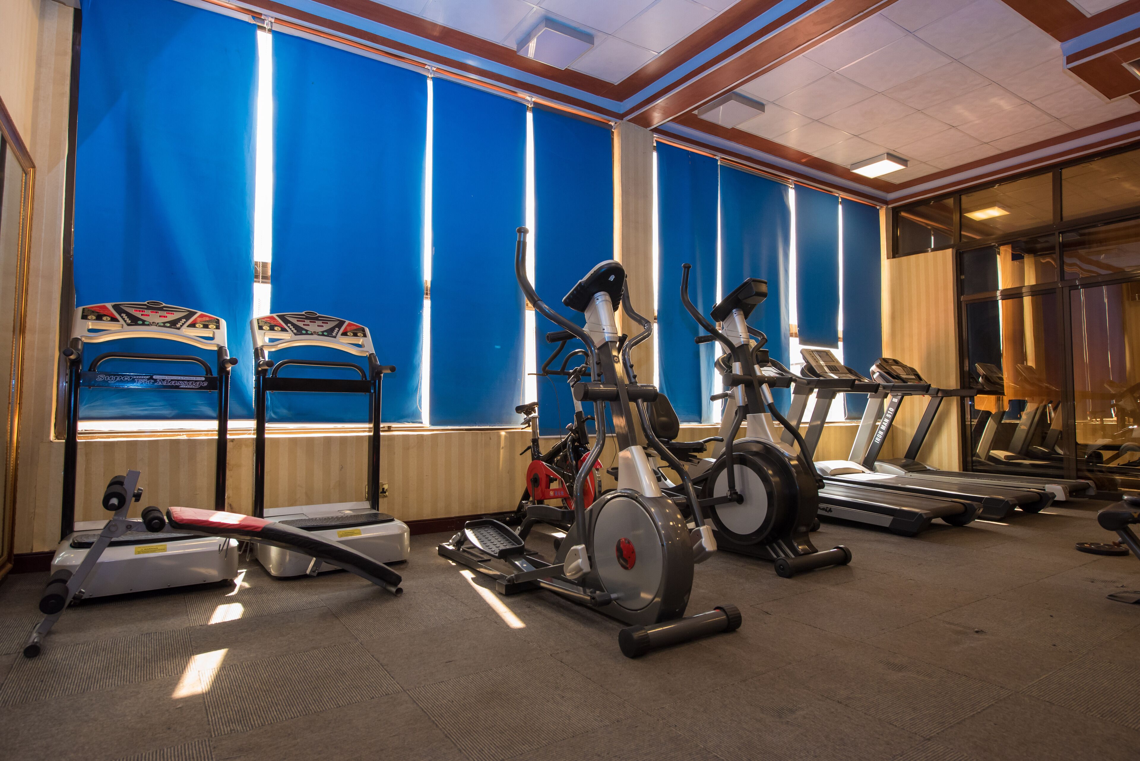A gym with exercise equipment including treadmills, stationary bikes, and a rowing machine.