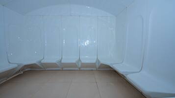 Simple, minimalist space with curved benches and a high ceiling.