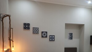 A hotel room with two beds, a small table, and a wall-mounted light fixture. - Napoli City Rooms (Naples)