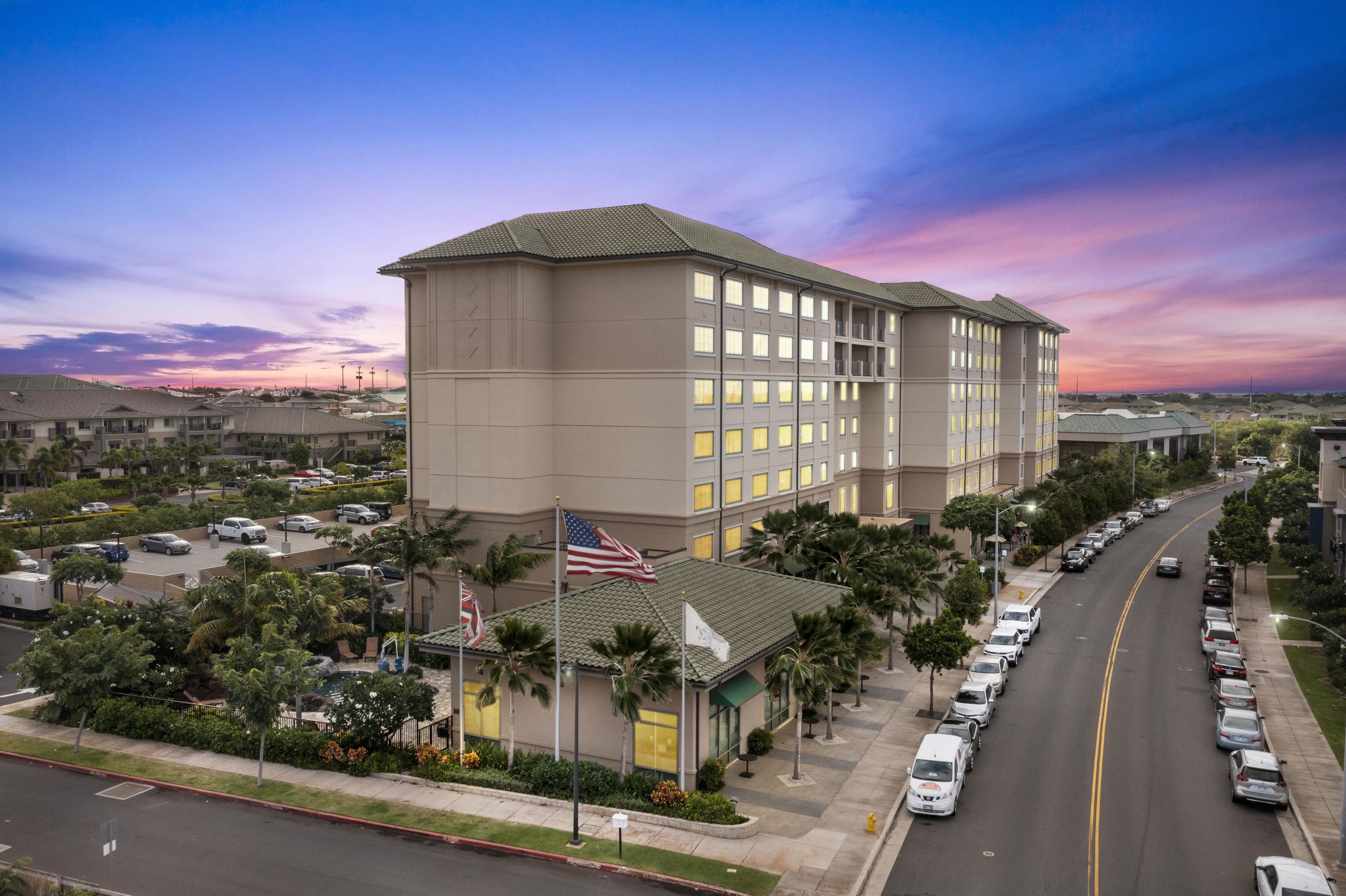 A multi-story hotel with a flat facade, large windows, and a flagpole with an American flag.
