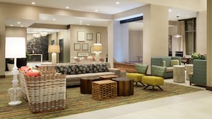 A modern living room with a sofa, armchairs, a coffee table, and a patterned rug. - Embassy Suites By Hilton Oahu Kapolei (Kapolei)