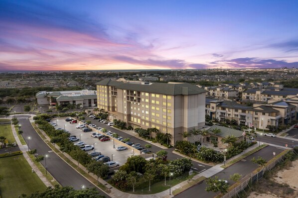 A large hotel with multiple floors, a parking lot, and a view of the surrounding area. - Embassy Suites By Hilton Oahu Kapolei (Kapolei)
