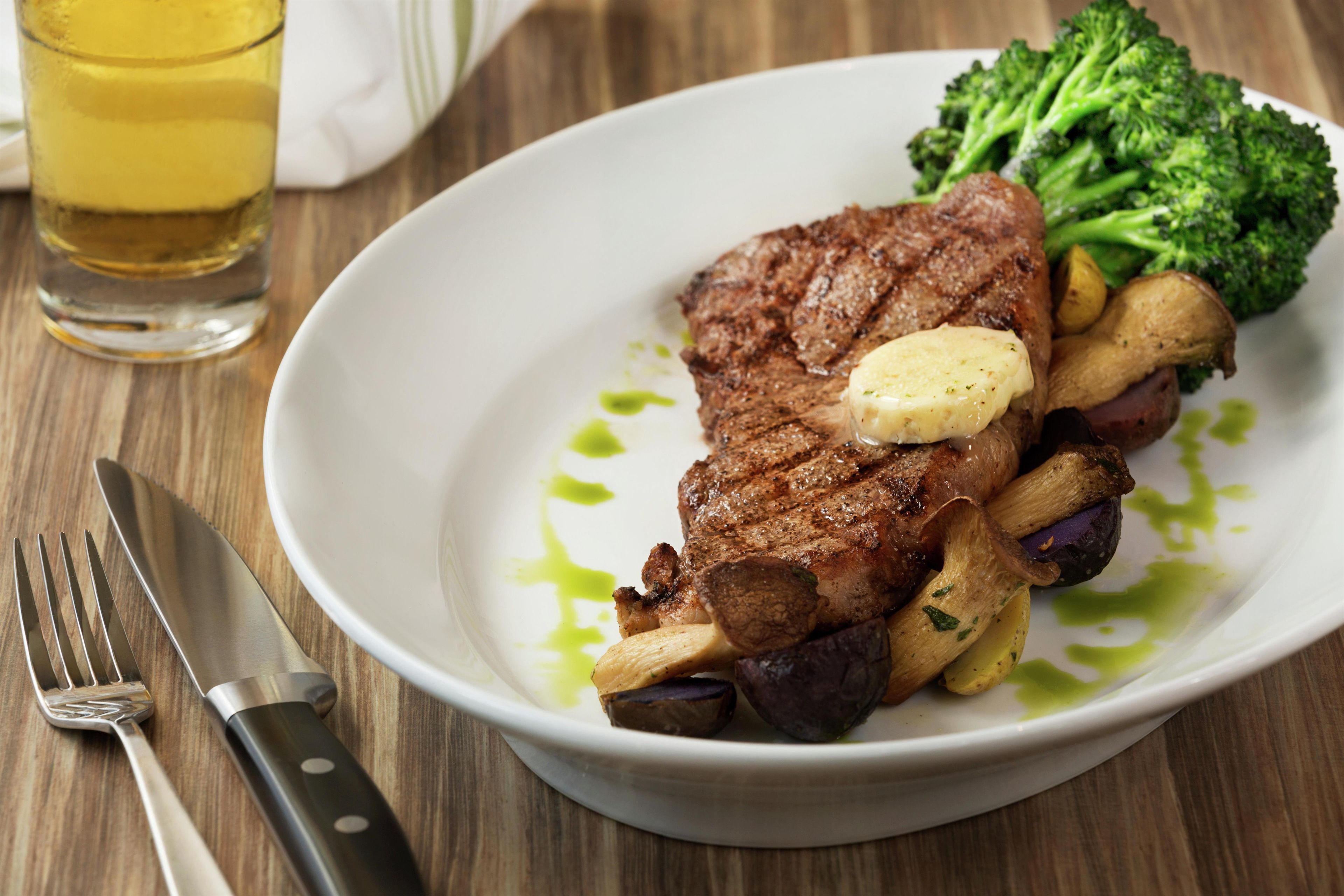 A plate of food with a steak, broccoli, and potatoes.