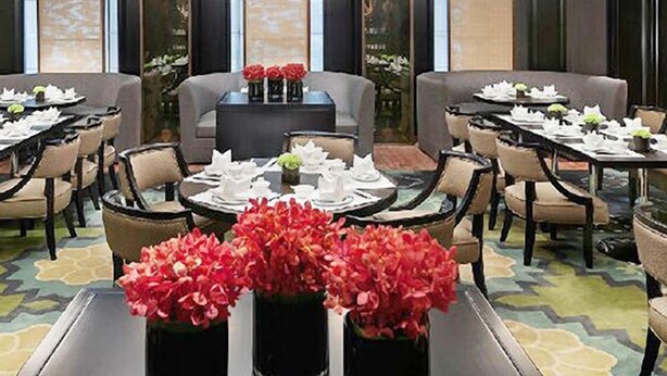A hotel dining area with multiple tables set for dining, surrounded by chairs. - Lamtin Longwin Hotel Wuhan (Wuhan)