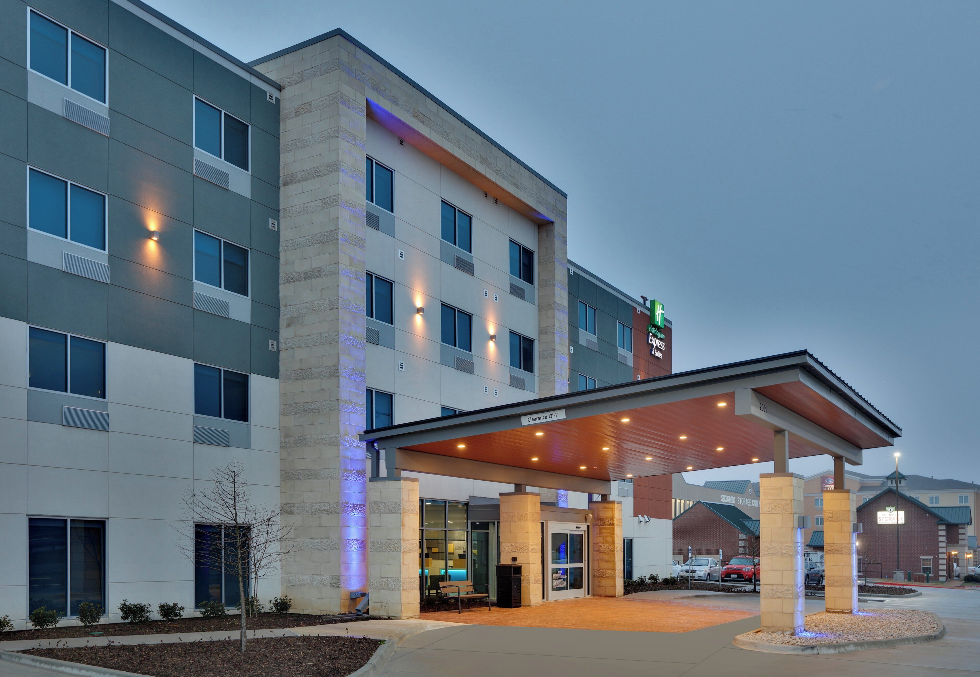 A hotel with a covered entrance, multiple windows, and a sign for the Holiday Inn Express & Suites.