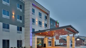 A hotel with a covered entrance, multiple windows, and a sign for the Holiday Inn Express & Suites.