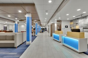 A modern hotel lobby with a central corridor, seating areas, and reception desks. - Holiday Inn Express & Suites Plano East - Richardson by IHG (Plano)