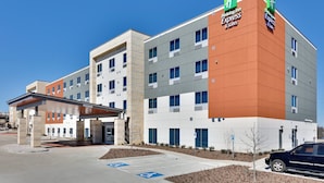 A Holiday Inn Express & Suites hotel with a modern design, featuring a covered entrance and a parking area with handicapped accessible spaces. - Holiday Inn Express & Suites Plano East - Richardson by IHG (Plano)