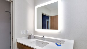 A modern bathroom with a white sink, a mirror, and a wooden vanity. - Holiday Inn Express & Suites Plano East - Richardson by IHG (Plano)