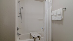 A bathroom with a shower, a bathtub, a small step stool, and a towel rack. - Holiday Inn Express & Suites Atchison by IHG (Atchison)