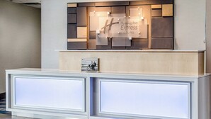 Una recepción con diseño moderno, que incluye un letrero de bienvenida y una foto enmarcada.