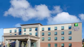 Hotel building with a flat roof and brick facade, featuring a covered entrance and multiple floors.