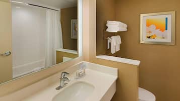 A modern bathroom with a large mirror, a sink, a toilet, and a towel rack.