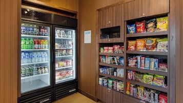 Un refrigerador para aperitivos y bebidas con estantes llenos de diferentes opciones.