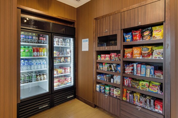 Un refrigerador para aperitivos y bebidas con estantes llenos de diferentes opciones.
