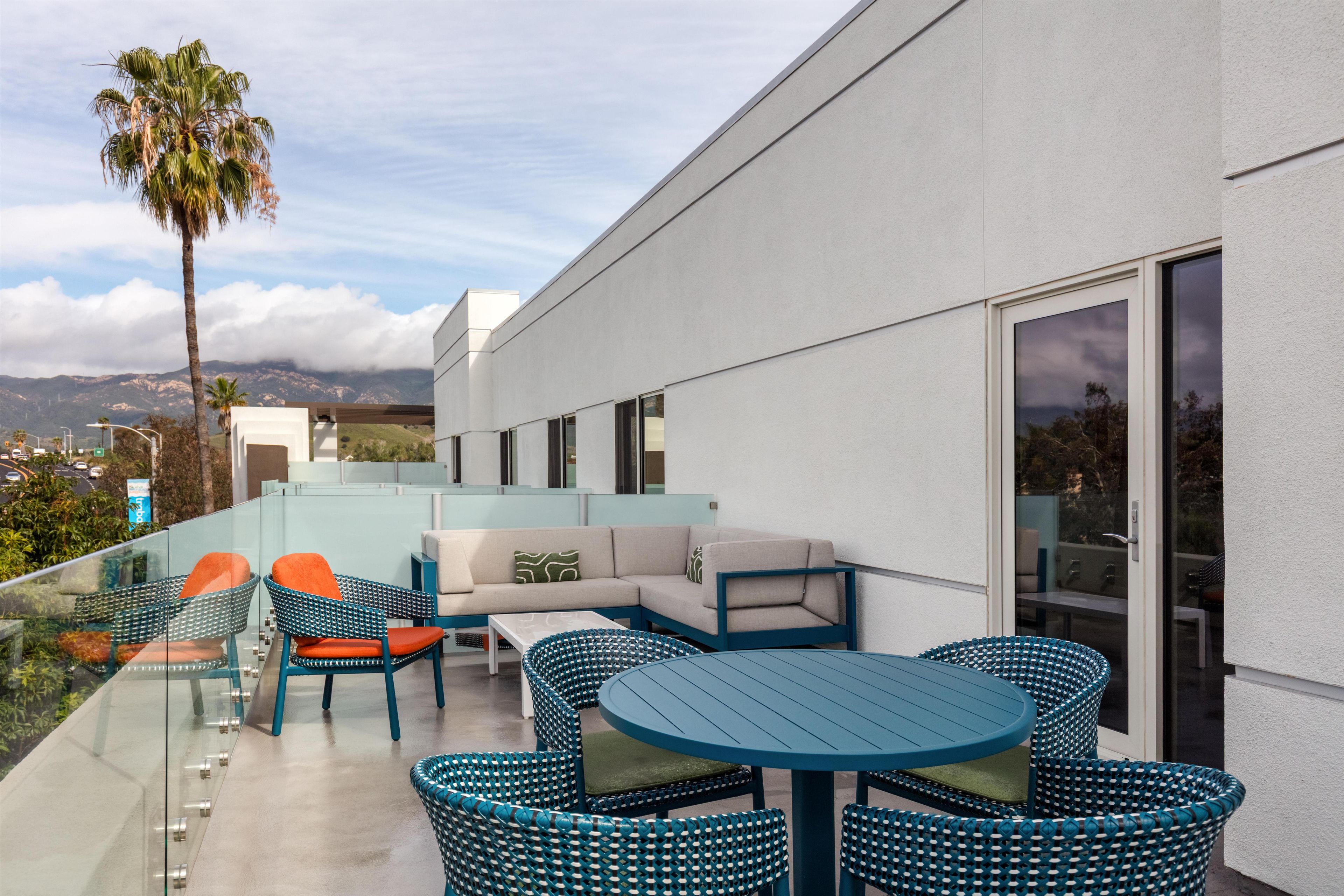 An outdoor patio with a sofa, chairs, and a table.