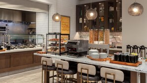 A modern kitchen with a coffee station, bar seating, and a chalkboard menu. - Hilton Garden Inn Santa Barbara / Goleta (Goleta)