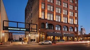 Ein Hotel mit markantem Eingang, auf dem "Homewood Suites" steht, mit einer klassischen Backsteinfassade und mehreren Fenstern.