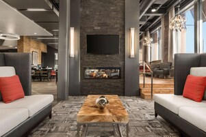 Un área de descanso moderna con chimenea, sofás y una mesa de centro.