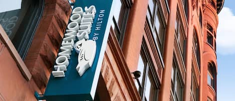 A sign for 'Homewood Suites by Hilton' on a building.