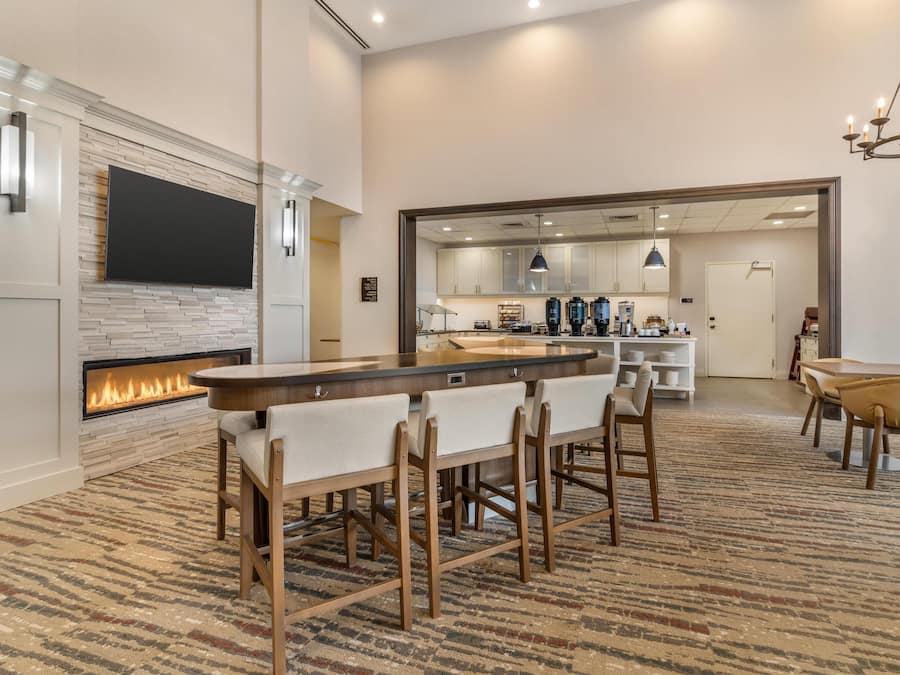 Una cocina moderna con televisión de pantalla plana, chimenea y comedor con barra.
