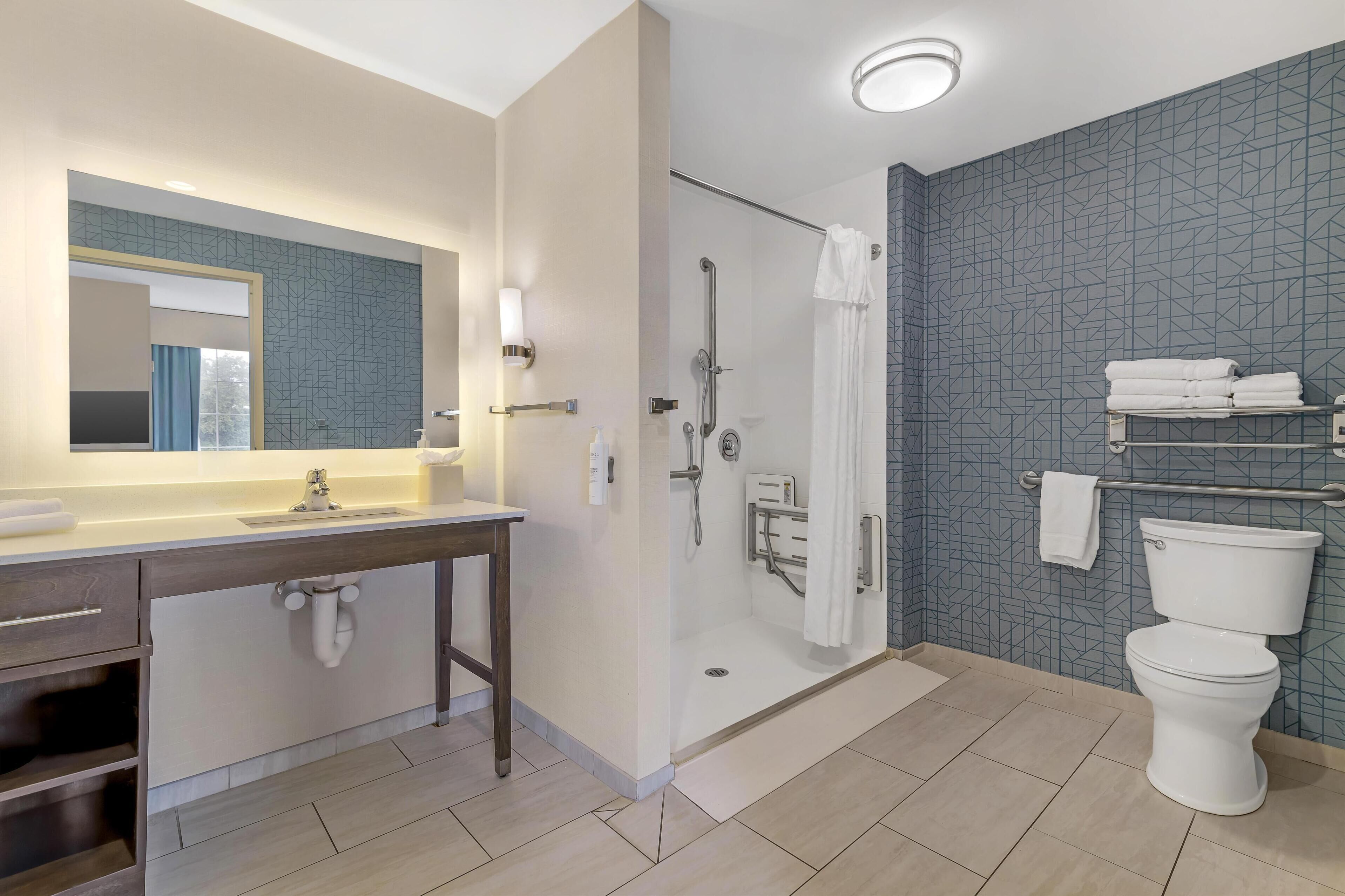A modern bathroom with a shower, toilet, and vanity.