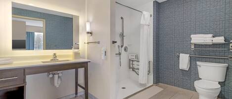 A modern bathroom with a shower, toilet, and vanity.