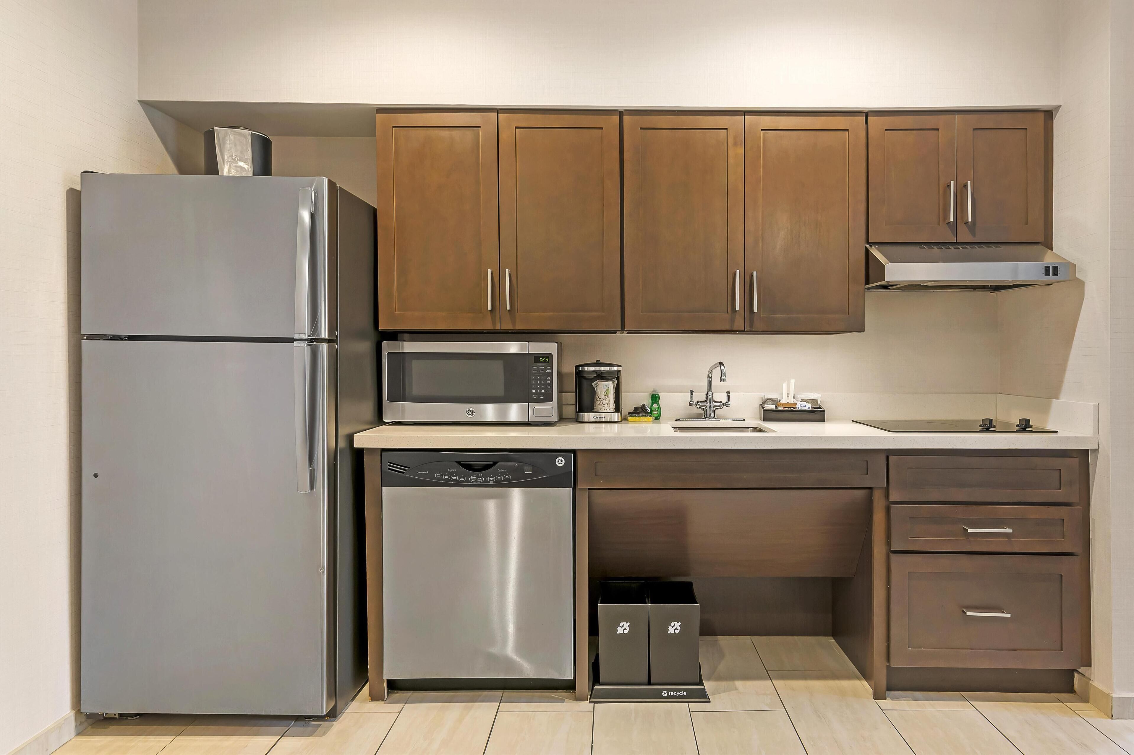 Una cocina moderna con electrodomésticos de acero inoxidable, armarios de madera y lavavajillas integrado.