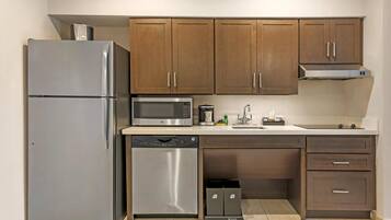 Una cocina moderna con electrodomésticos de acero inoxidable, armarios de madera y lavavajillas integrado.