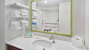 Une salle de bain moderne avec un lavabo blanc, un miroir et des porte-serviettes.