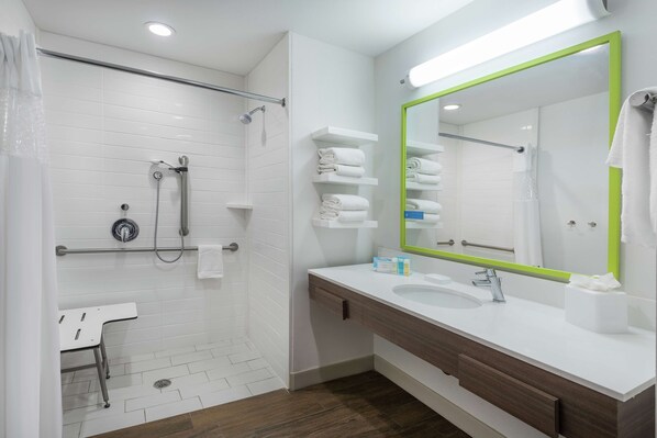 A modern bathroom with a shower, a sink, and a mirror.