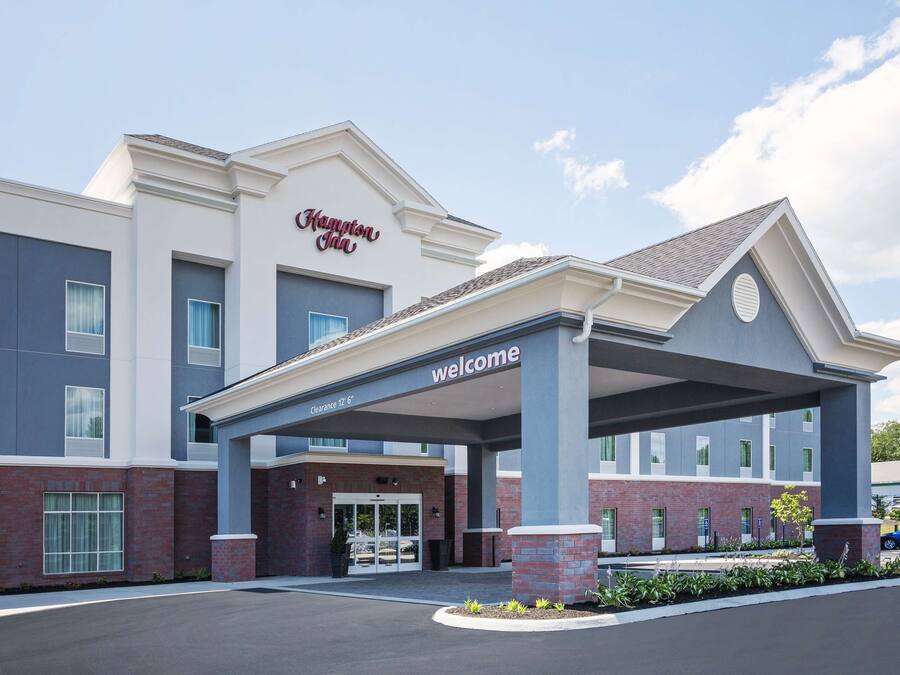 A Hampton Inn hotel with a covered entrance, clear signage, and a brick facade.