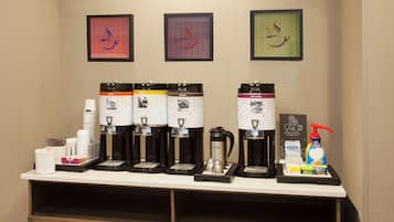 Un angolo caffè con diverse macchinette e una selezione di cialde.